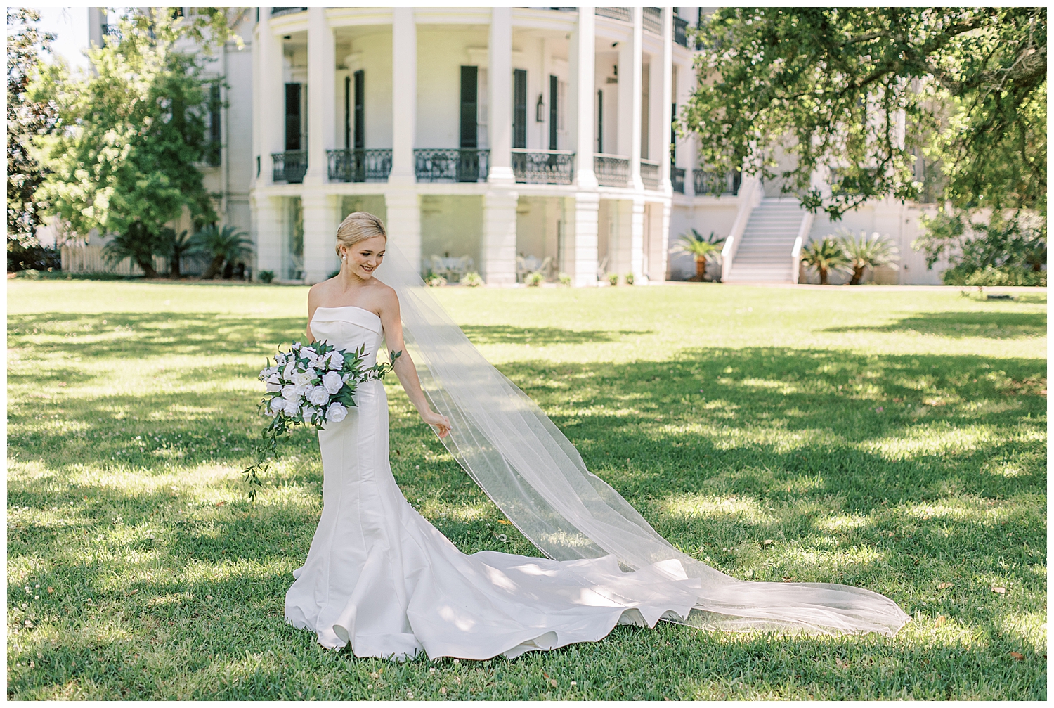 A bride looks backward while standing in front of Nottoway Plantation.