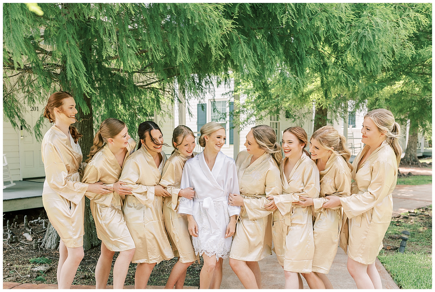 A bride laughs with the bridesmaids.