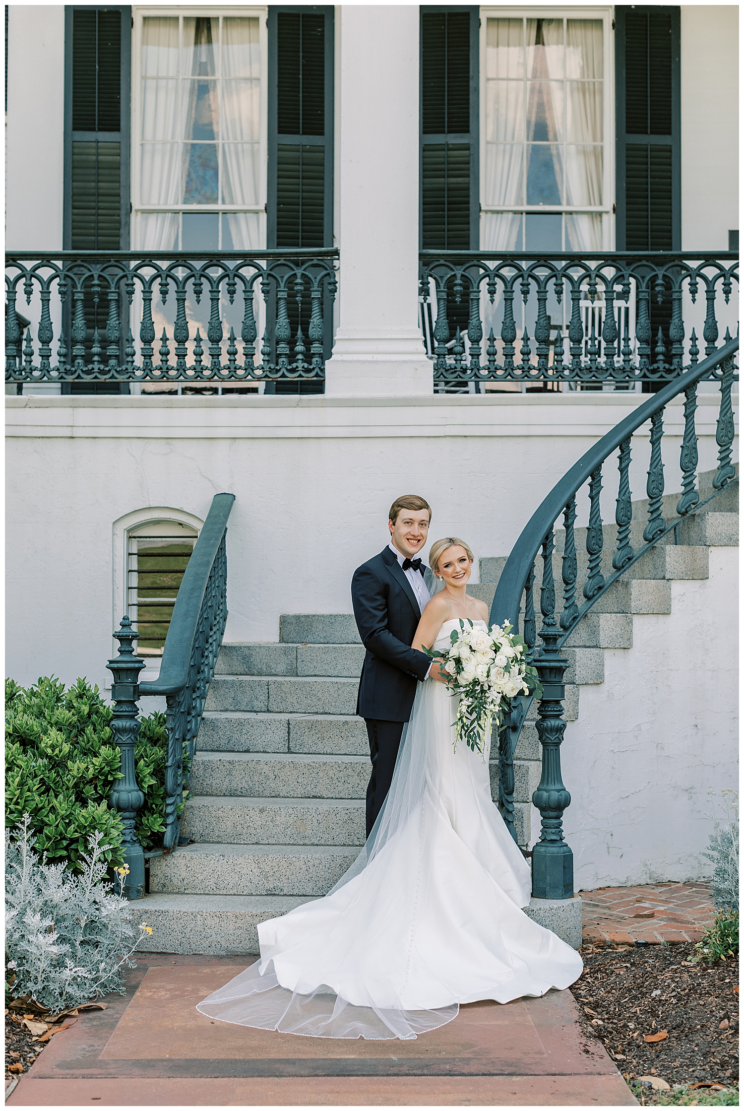 A bride and groom stand on the steps of Nottoway Plantation.