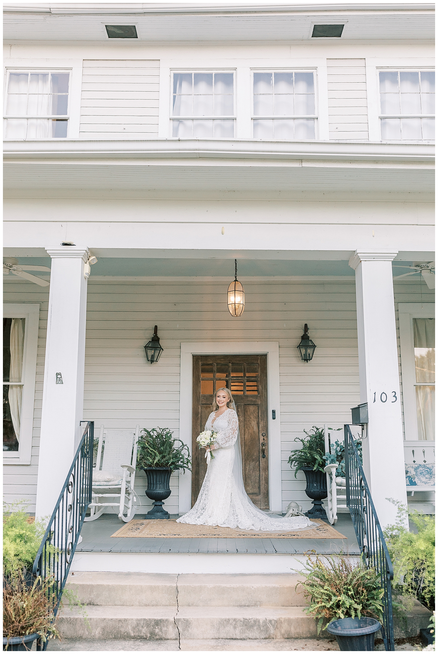 A bride stands on the porch of a historic home in Hattiesburg.