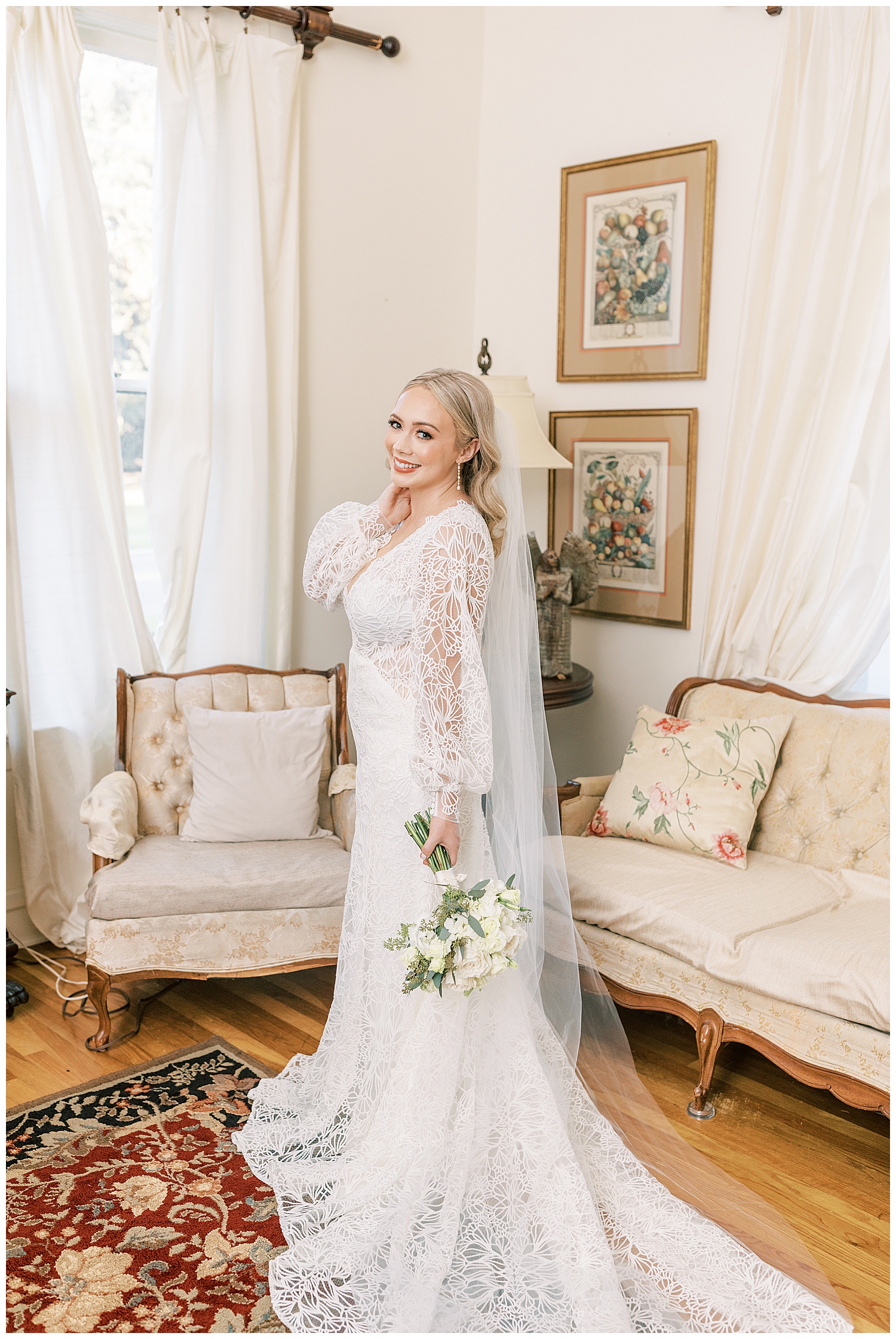 A bride stands in front of antique furniture.