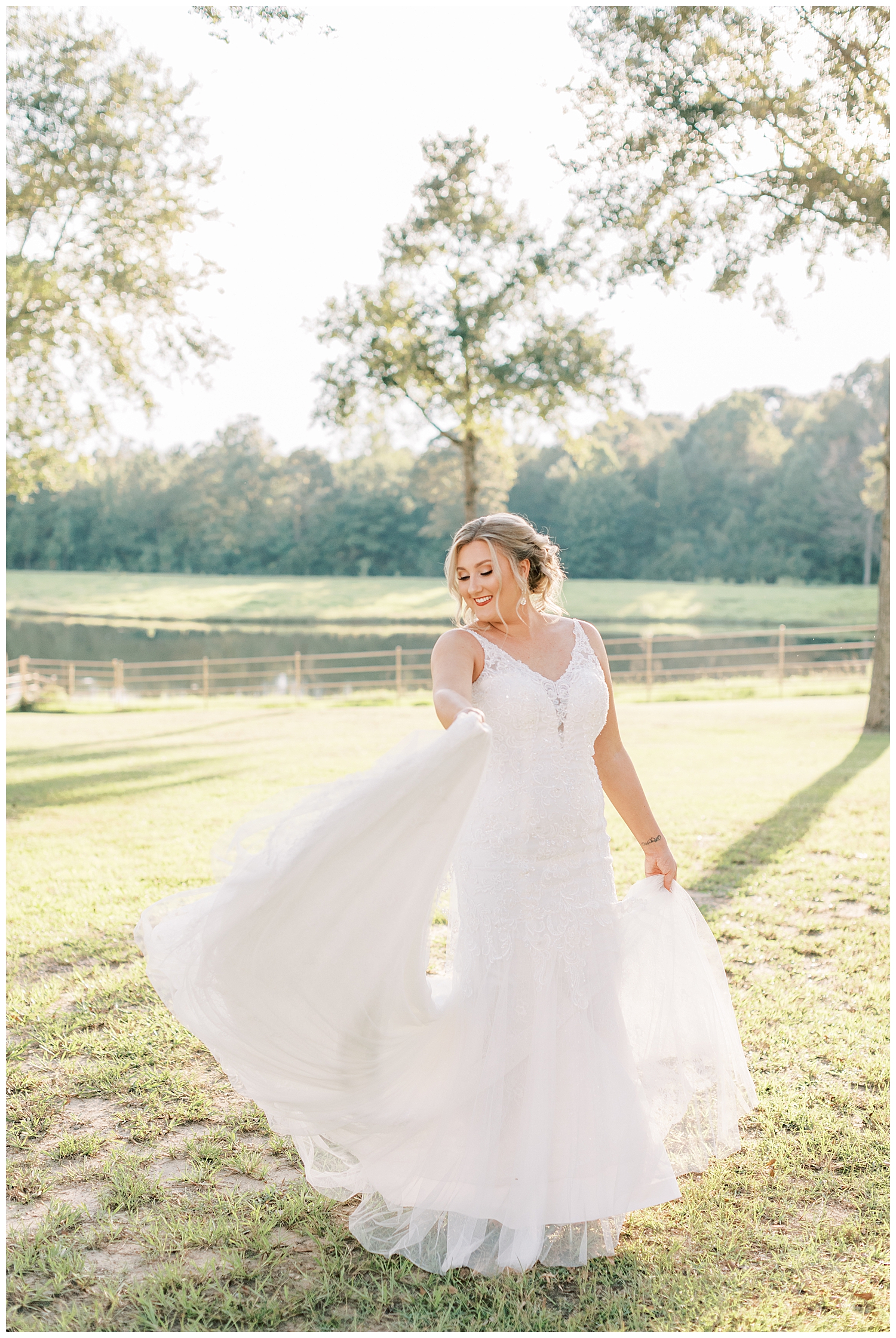 A bride twirls her dress in front of a lake.