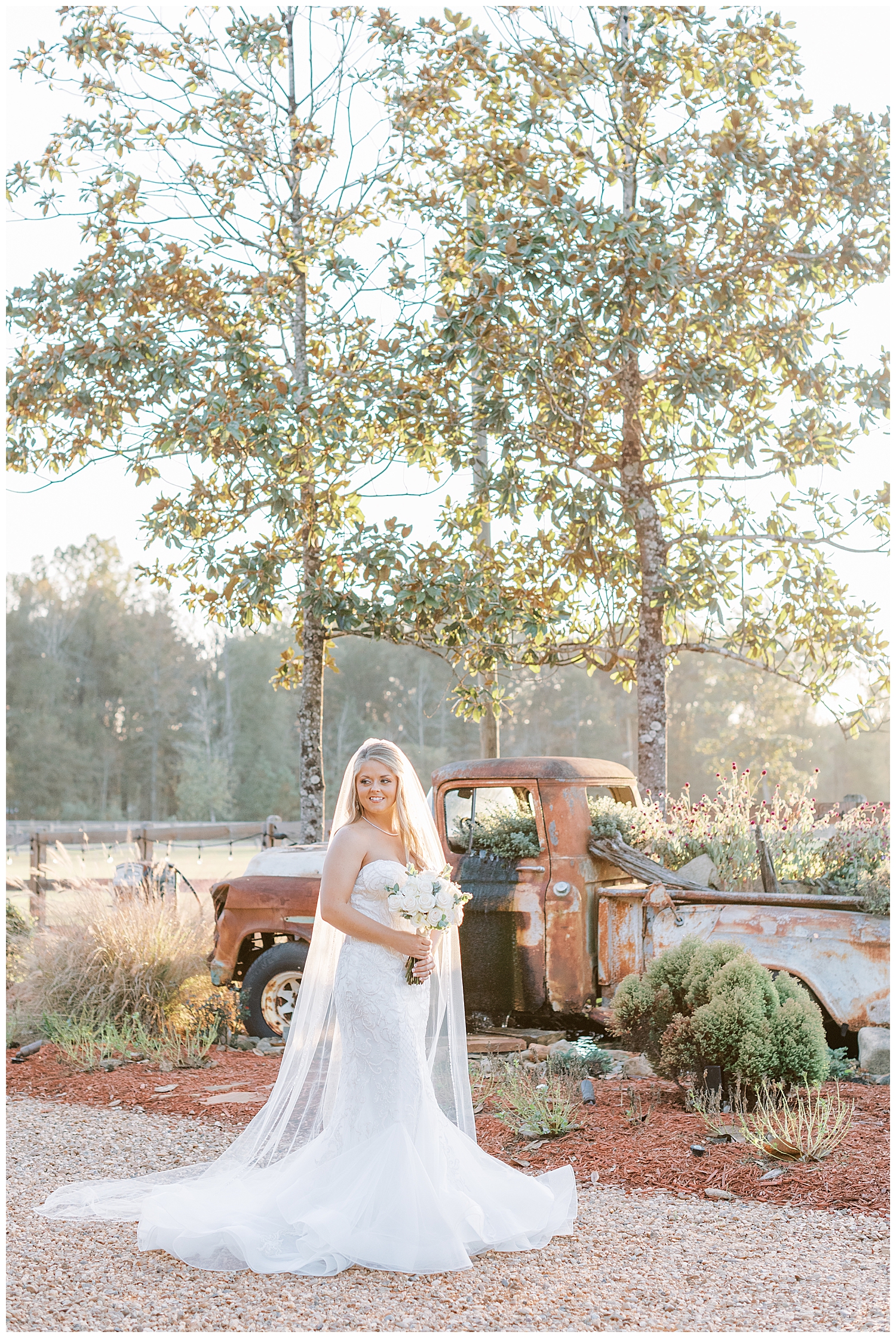 A bride stands in front of a truck at Sullivan Barn.