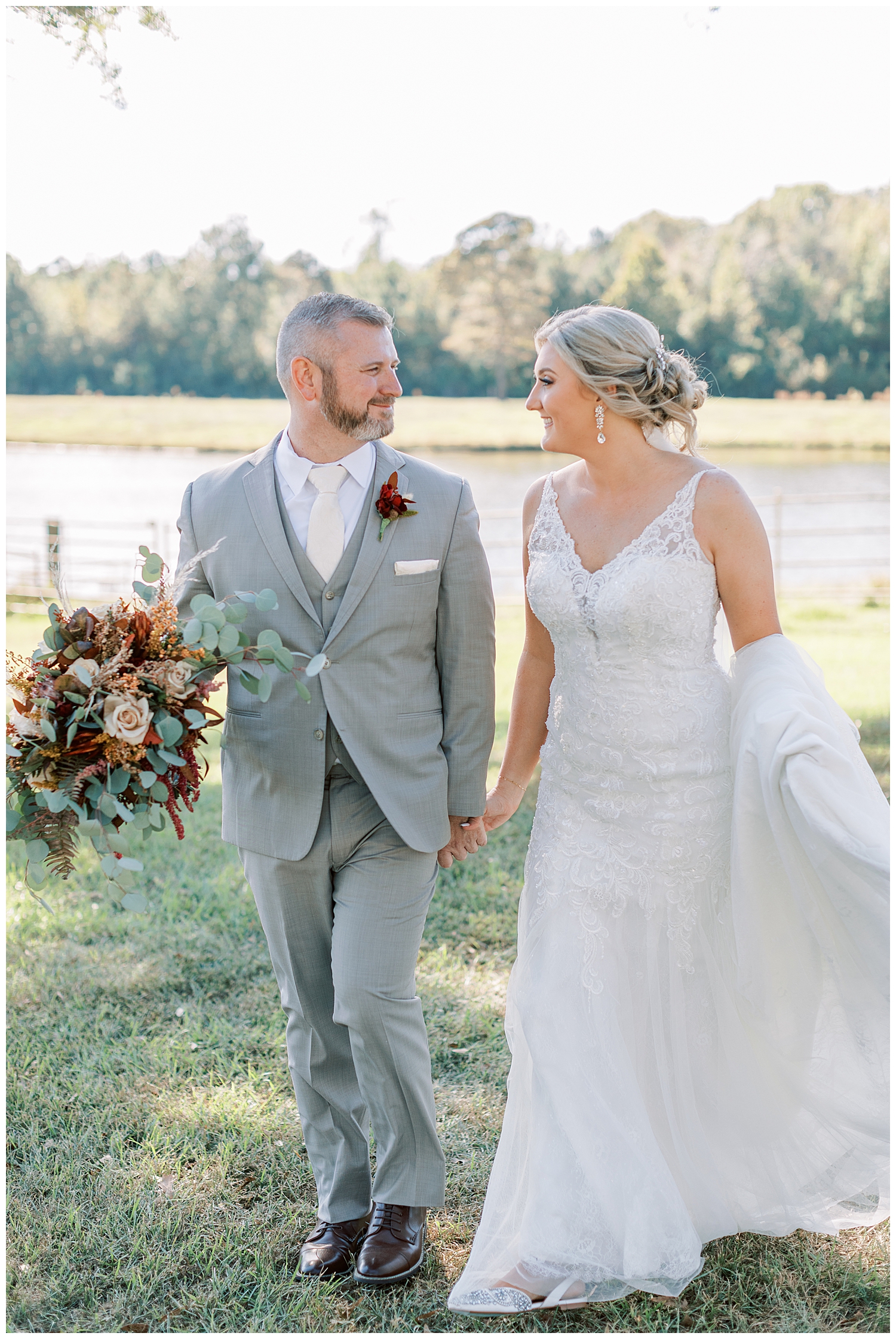 The groom holds the bride's bouquet at Three Lakes Manor in Poplarville.