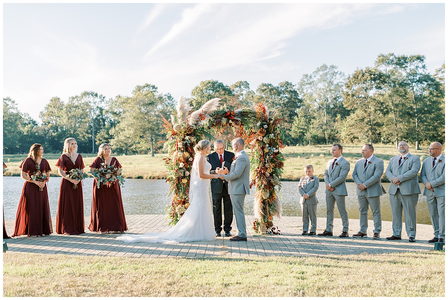 A wedding ceremony takes place in front of a lake at Three Lakes Manor in Poplarville.