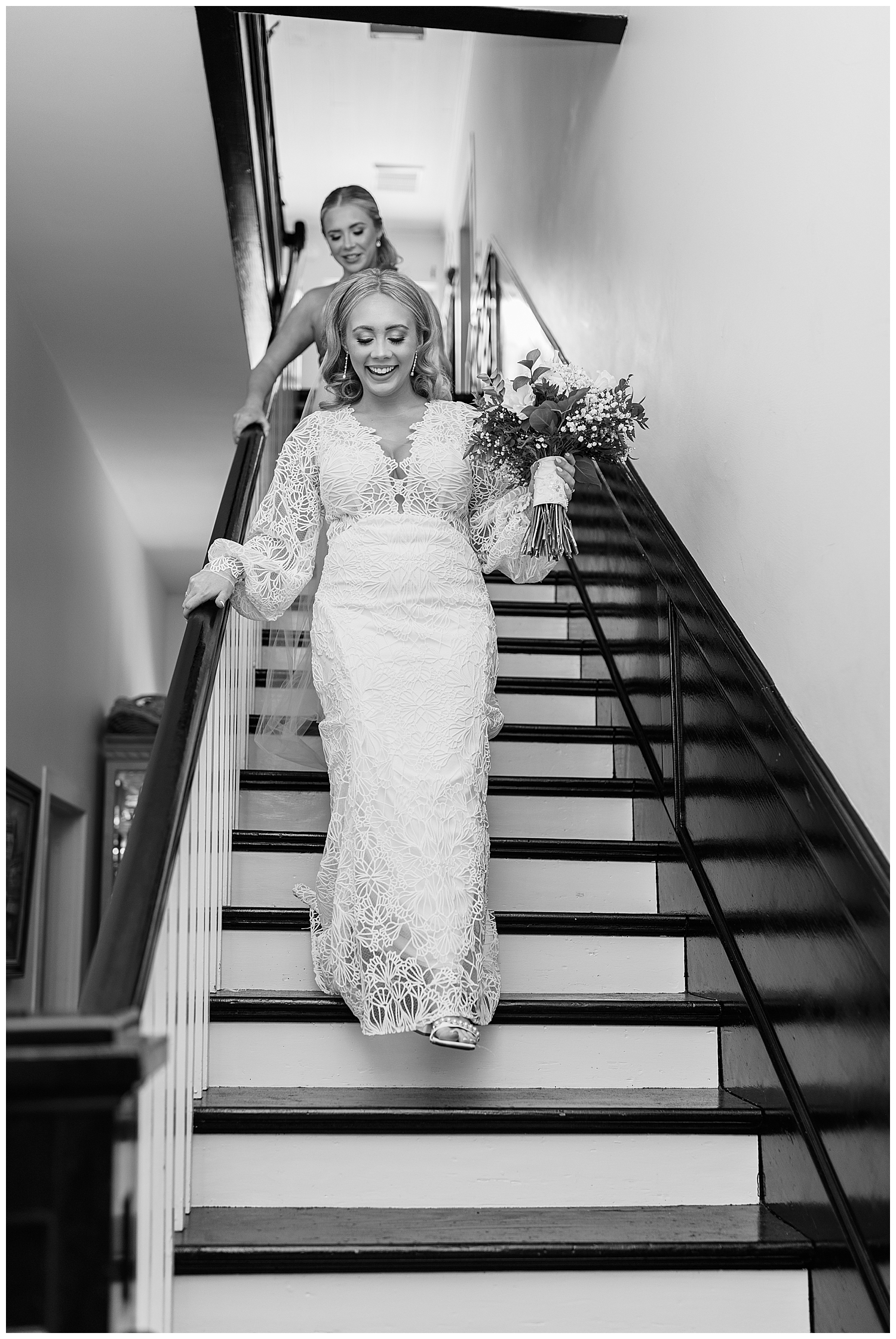 A bride and her sister walk down the stairs.