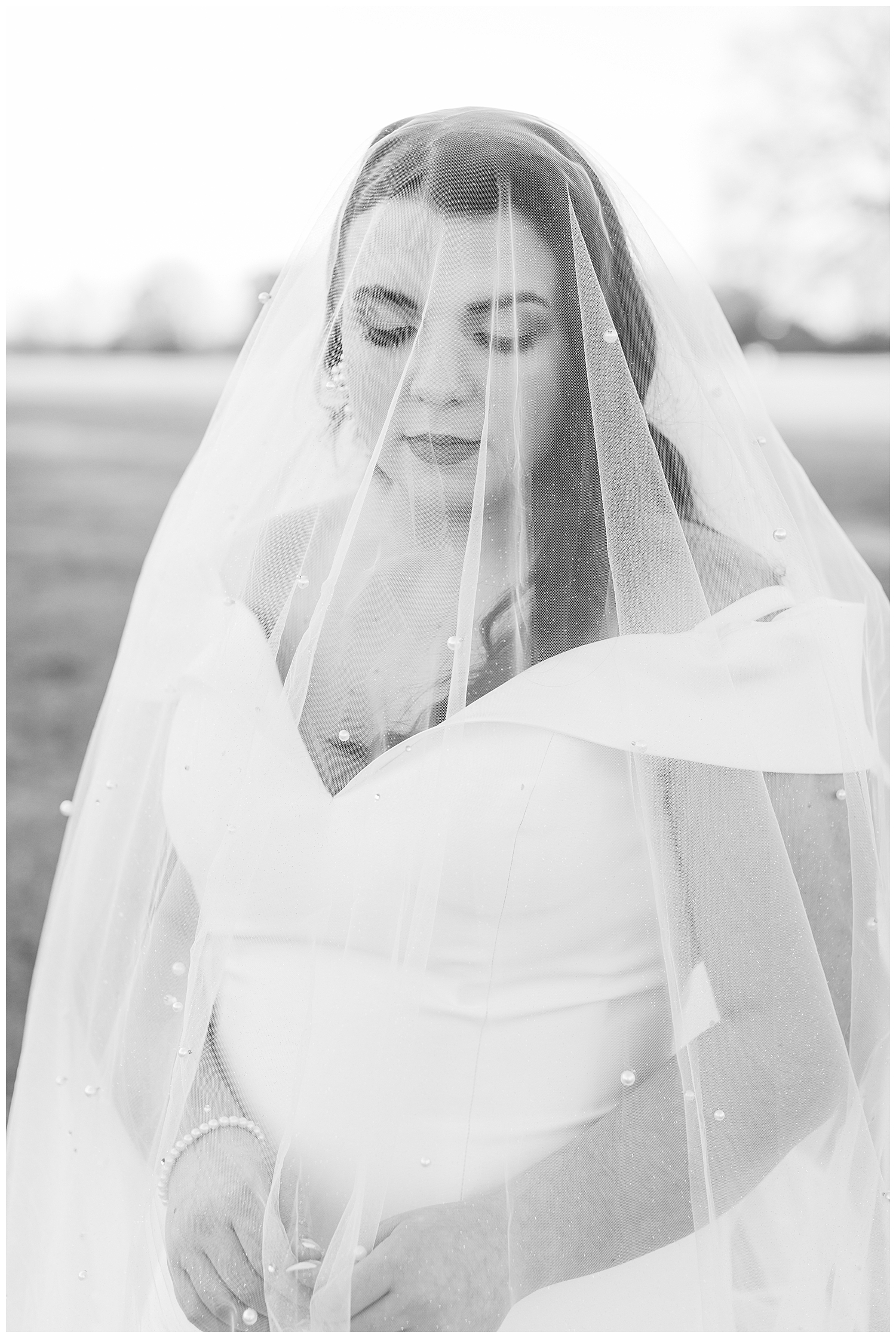 A bride is covered by the pearl veil.