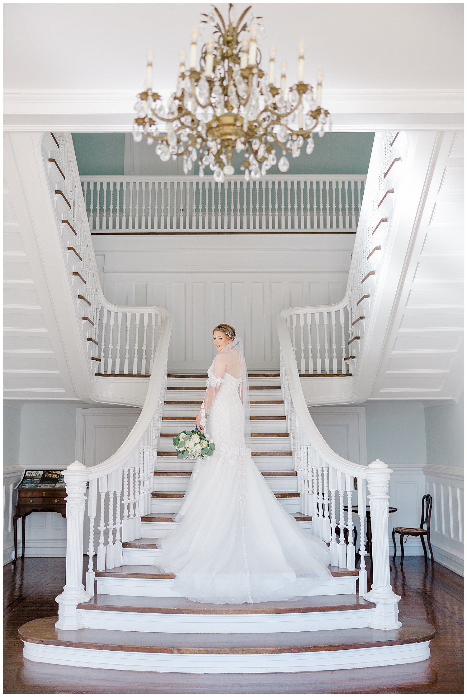 A bride stands on the staircase at Butterfield Mansion.